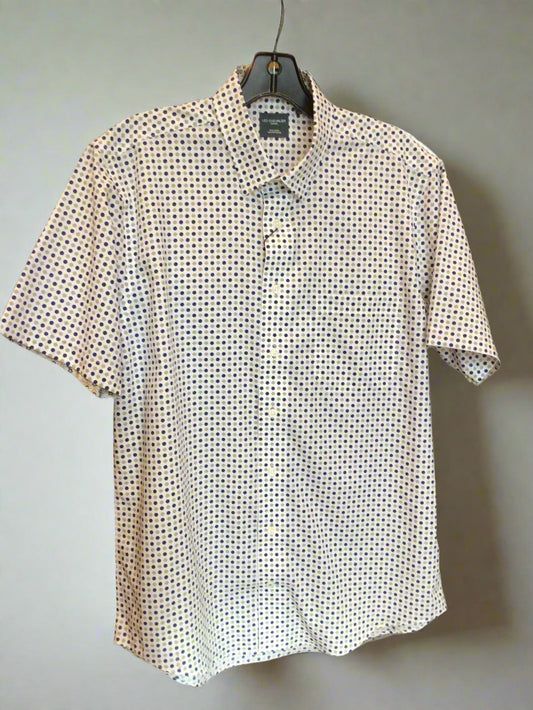 White shirt with black pattern on a hanger against a dark background